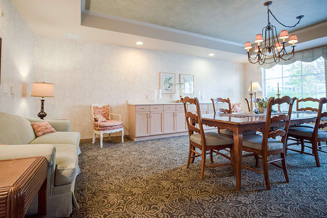 A cozy dining room with a wooden table set and elegant chandelier.
