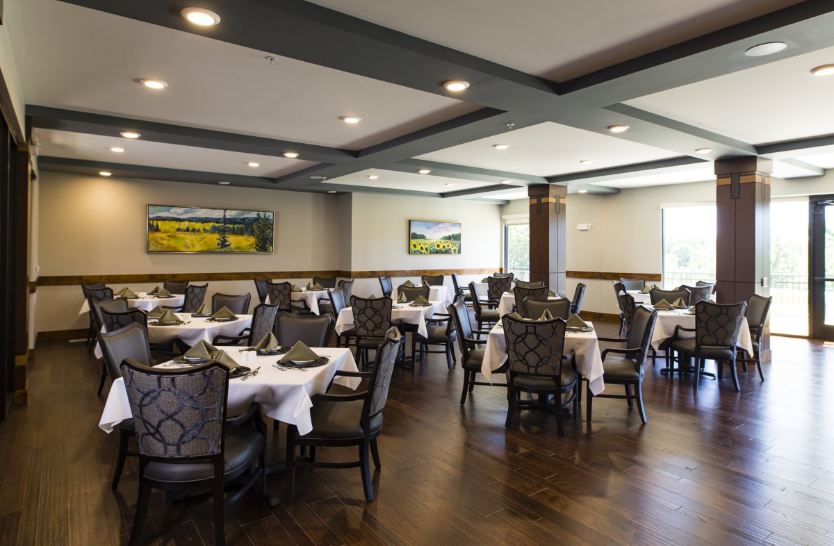 A spacious restaurant dining room with neatly arranged tables and chairs.