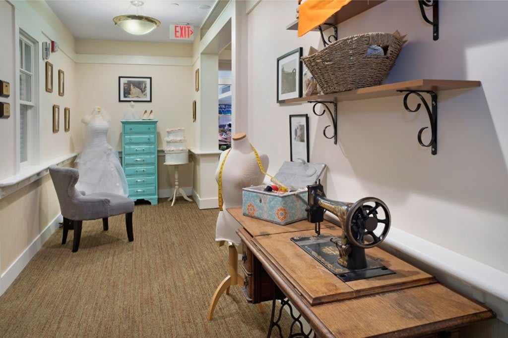 A cozy sewing workspace featuring a vintage sewing machine and a mannequin, set in a well-decorated interior.