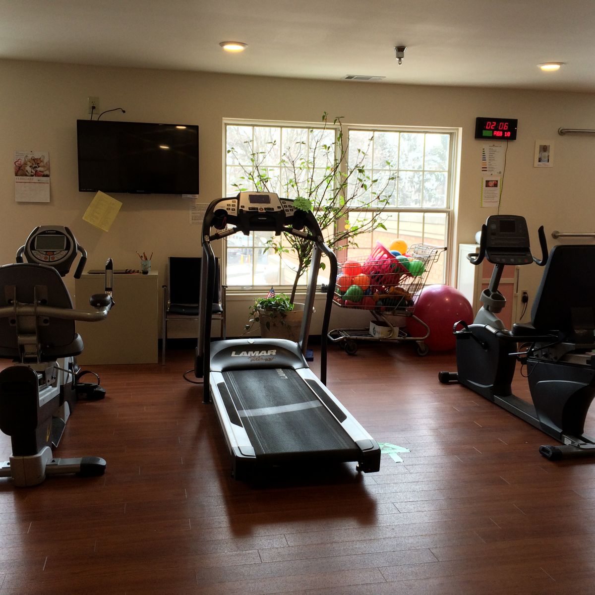 A small indoor gym with a treadmill and exercise bikes.