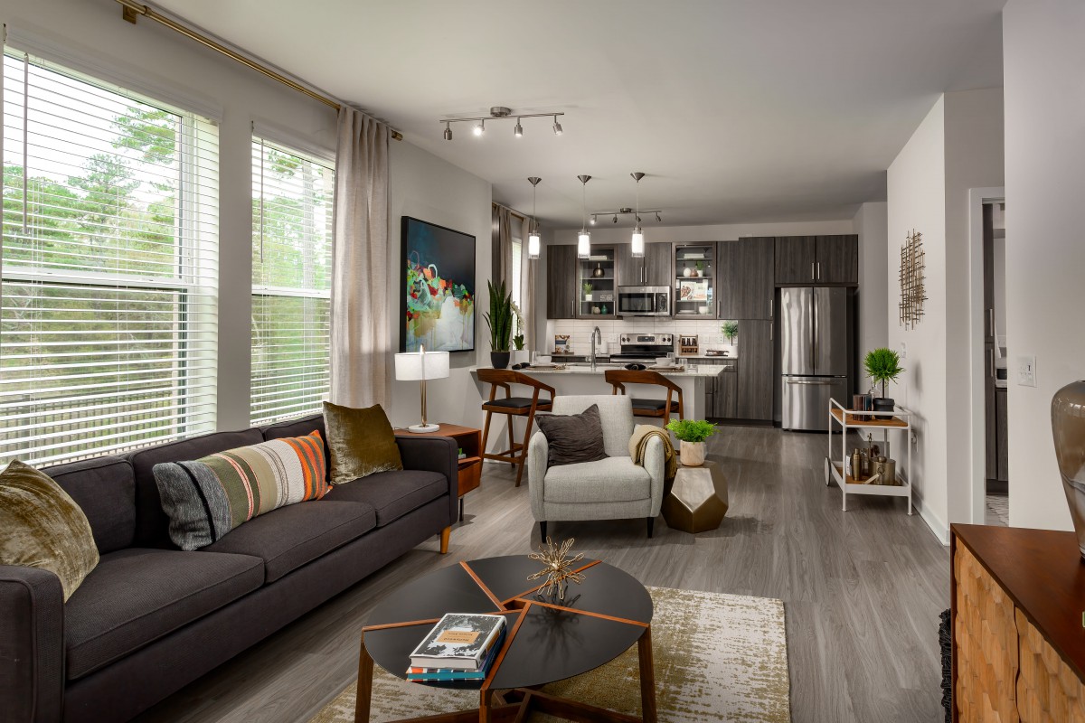 A modern living room and kitchen with an open floor plan, featuring contemporary furniture and stylish decor.