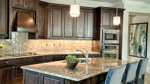 A modern kitchen featuring rich wood cabinetry and elegant granite countertops, illuminated by stylish pendant lights.