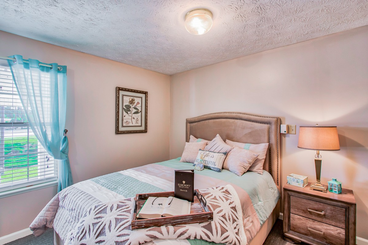 A cozy bedroom with soft lighting, a neatly made bed, and elegant decor.