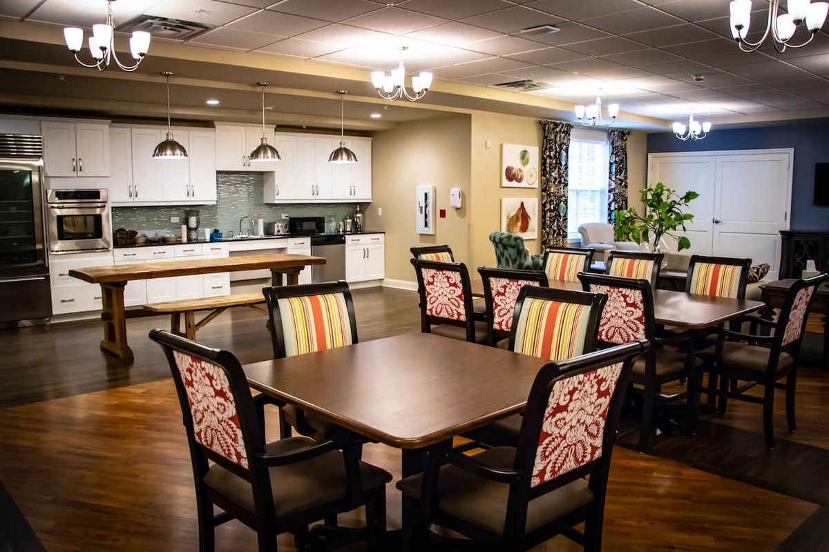 A modern and cozy dining area with a connected kitchen space and patterned chairs.