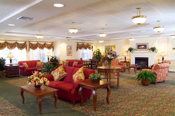 A well-decorated living room with comfortable sofas, elegant tables, and warm lighting.