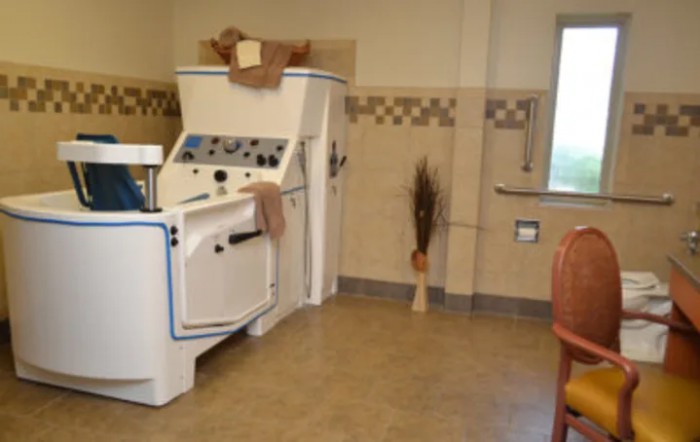 A room with a vintage laundry machine and folded towels.