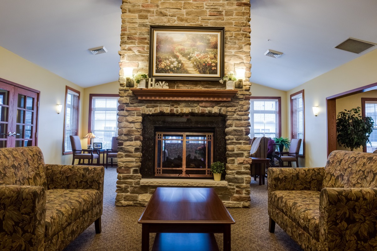 A cozy living room featuring a stone fireplace, elegant furniture, and warm lighting.