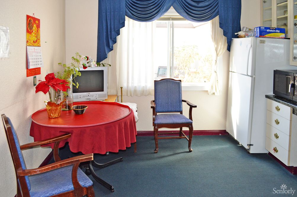 A cozy living room with a red tablecloth, blue curtains, and classic furniture.