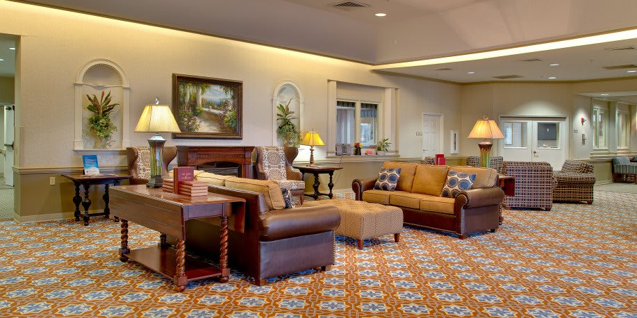 A cozy living room with comfortable sofas and armchairs, adorned with decorative elements and warm lighting.