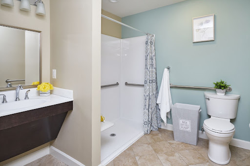 A clean and modern bathroom featuring an accessible shower, sink, and toilet.