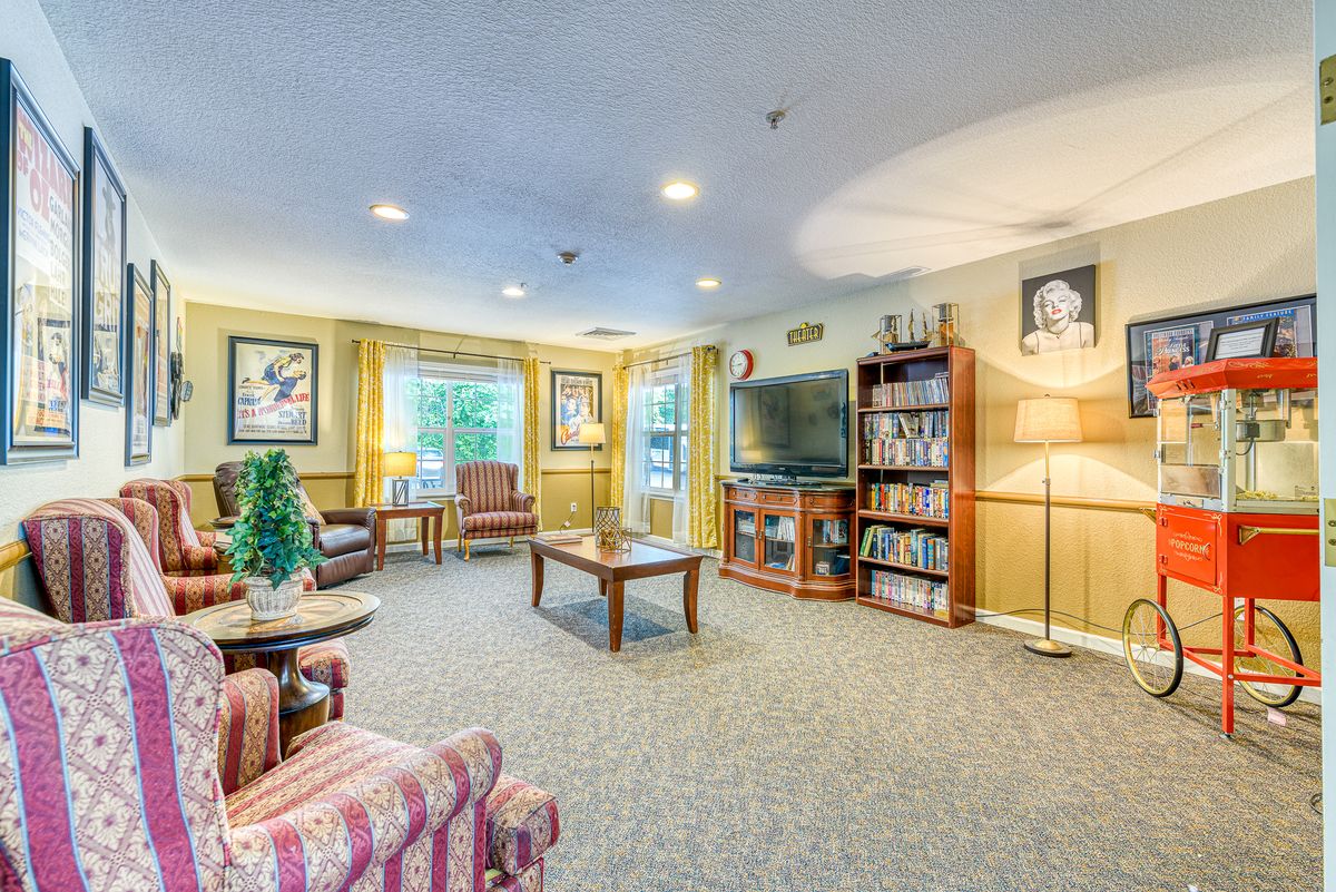 A cozy living room with comfortable seating, a television, and bookshelves filled with books.