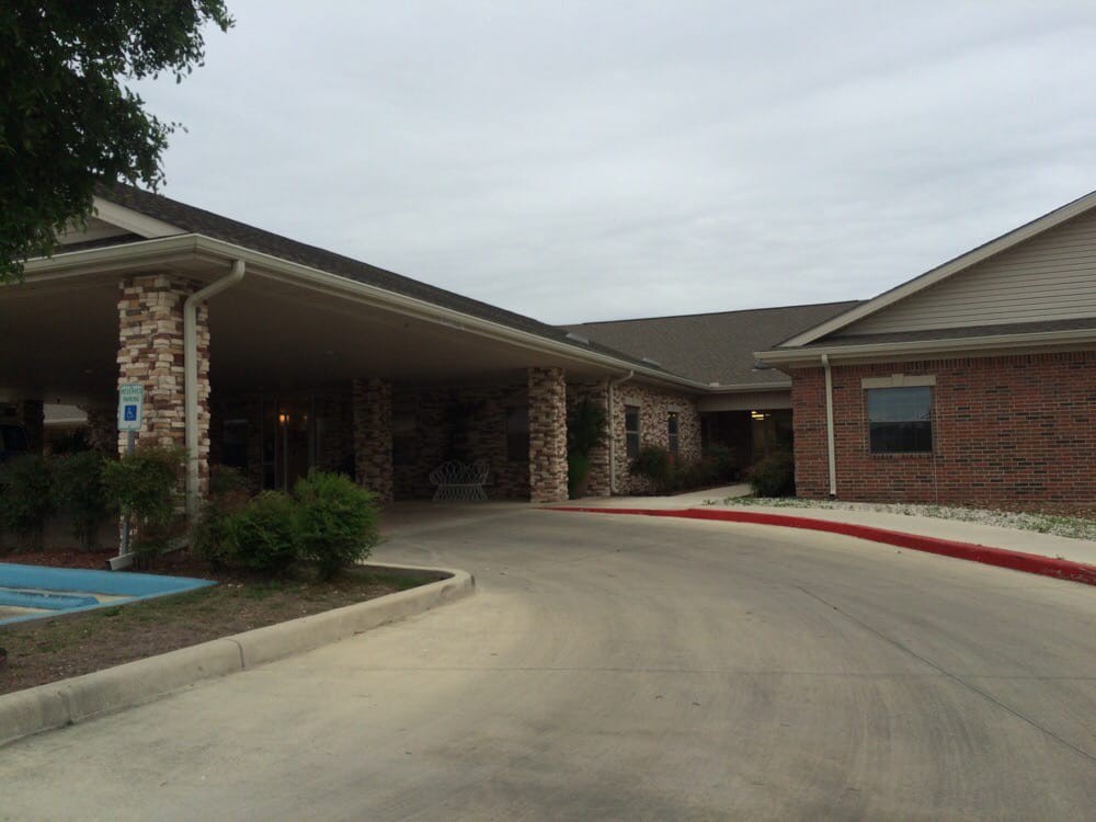 An exterior view of a brick building with an entrance and driveway.