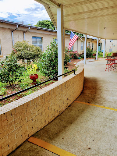 A peaceful outdoor courtyard featuring a garden and an American flag.