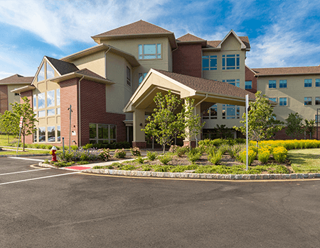 A residential building with landscaped surroundings under a clear blue sky.