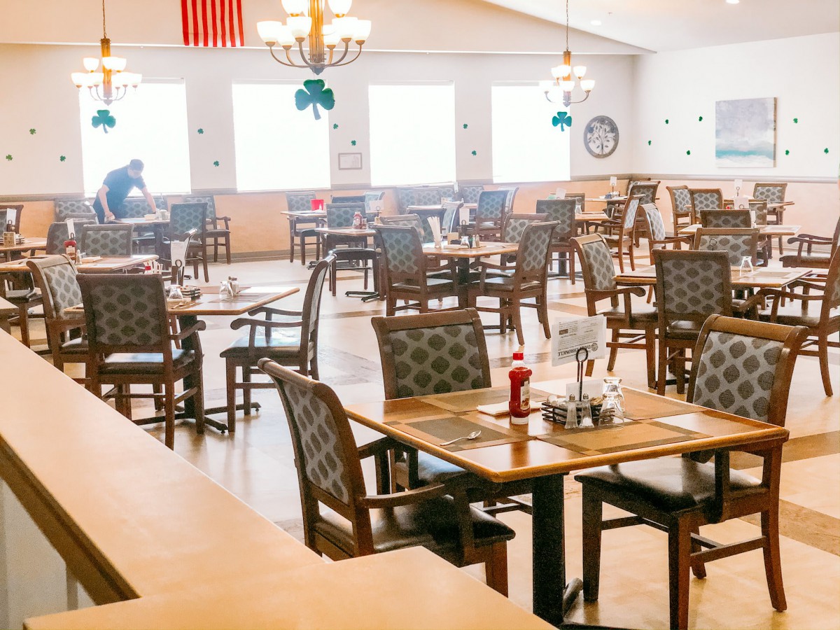 A bright and spacious restaurant dining area with neatly arranged tables and chairs.