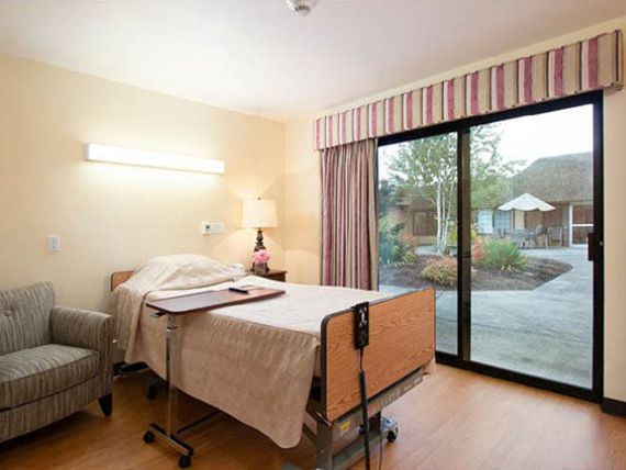 A hospital room with a bed and a large window.