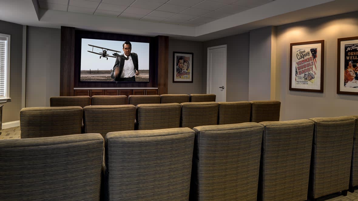 A cozy home theater setup with comfortable seating and a large screen displaying a movie.