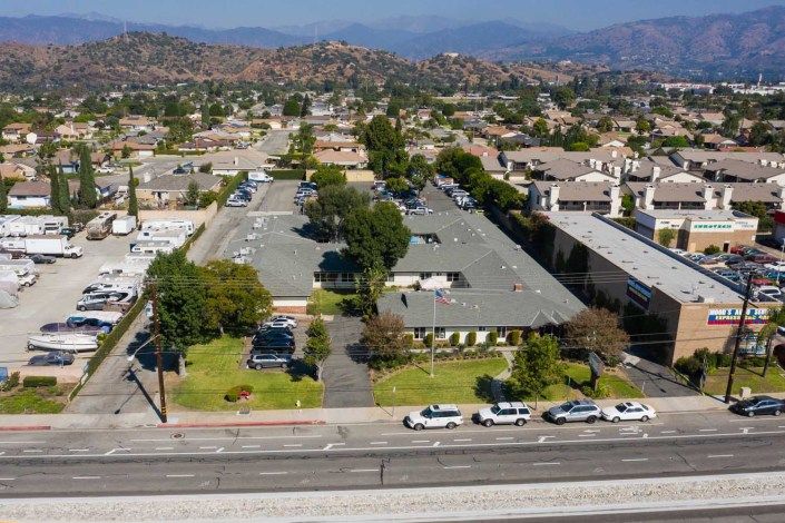 Aerial view of a suburban area with buildings, roads, and vehicles.