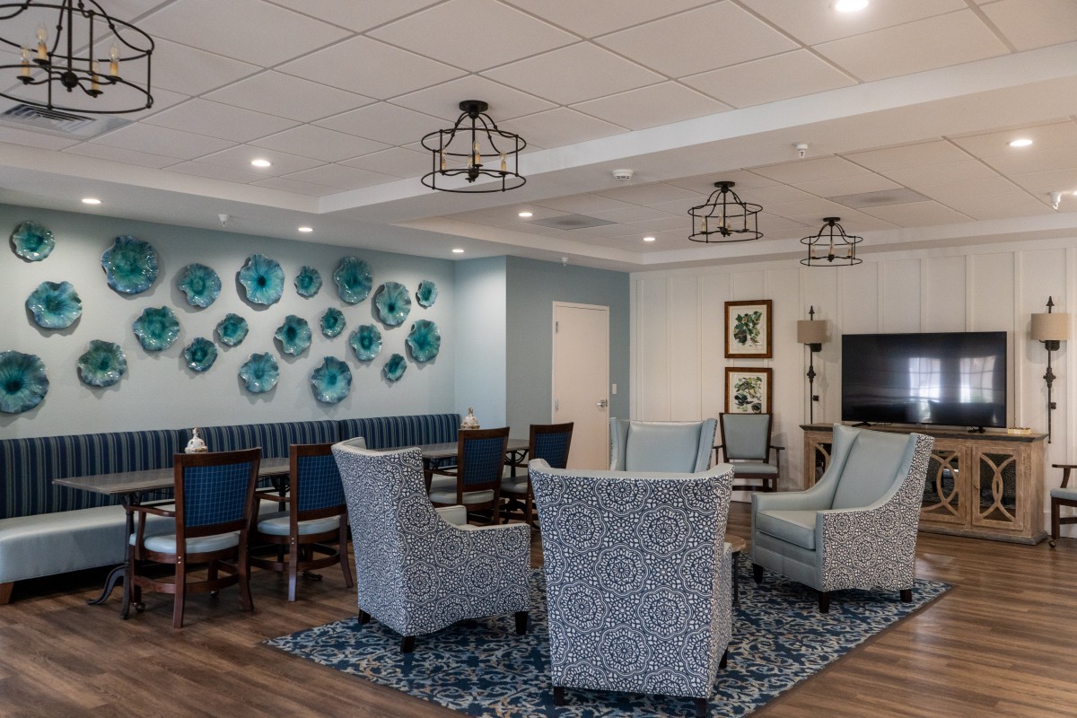 A modern living room interior with cozy seating and blue decor.
