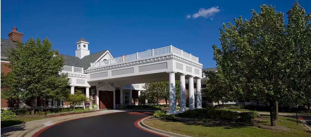 A modern building entrance with columns under a clear blue sky.