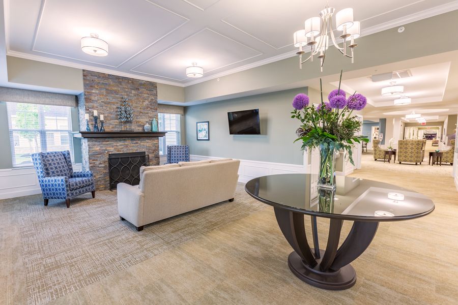 A modern lobby with elegant decor, featuring a sofa, fireplace, and television.