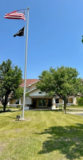 A charming building surrounded by lush greenery and a clear blue sky.