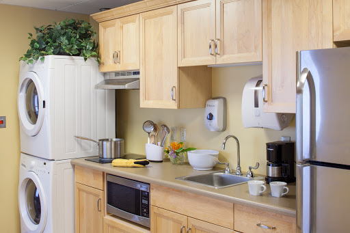 A well-equipped kitchen featuring wooden cabinets, a countertop with various appliances, and cooking essentials.
