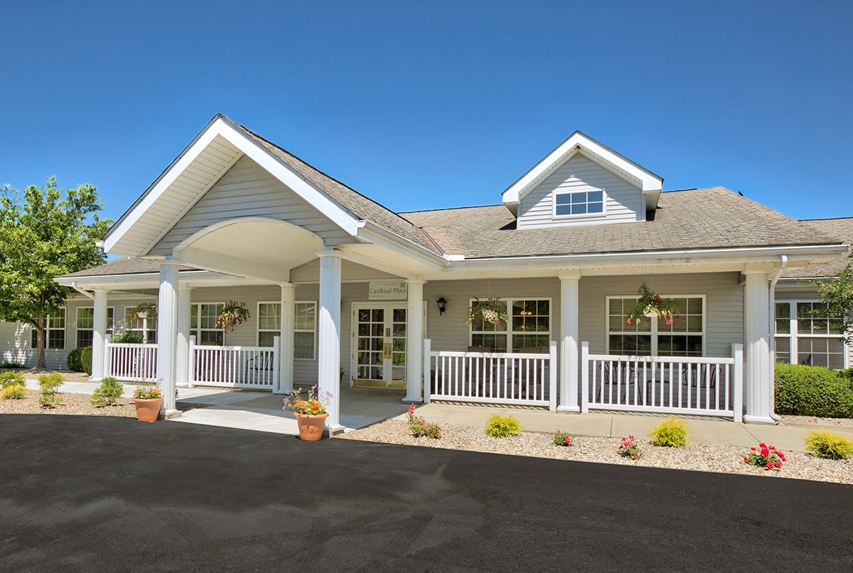 A charming residential building with a covered porch and a welcoming driveway.
