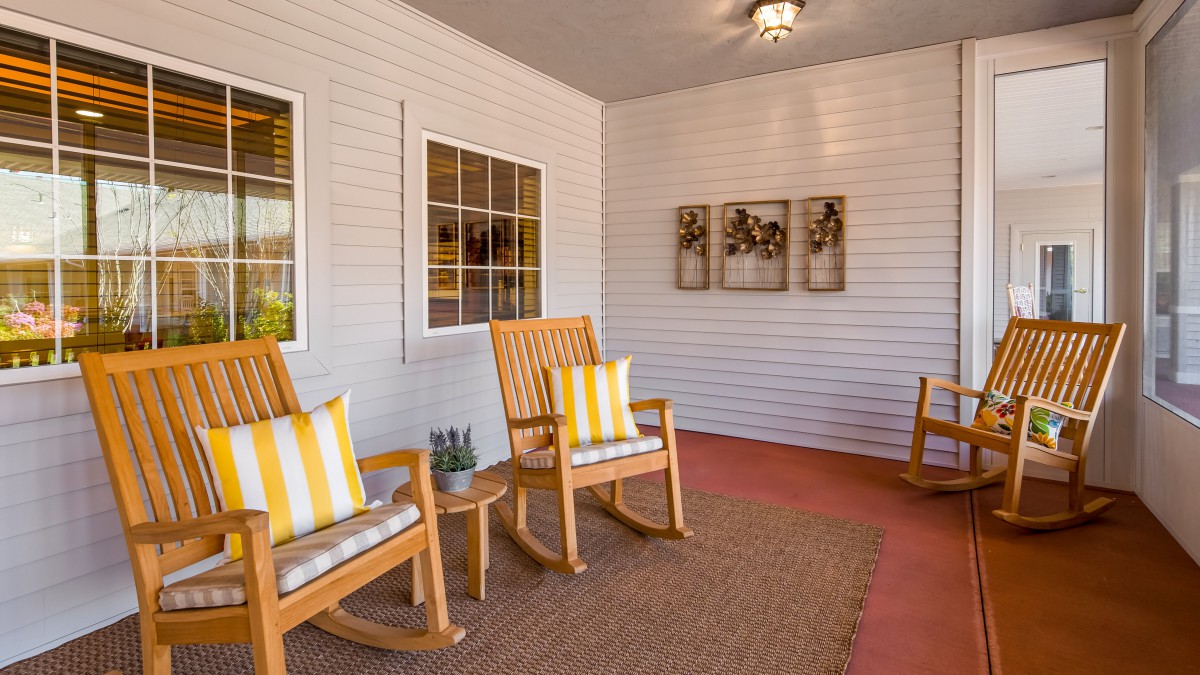 A cozy porch with wooden rocking chairs and striped cushions.