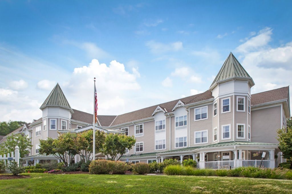 A residential building with a manicured lawn and clear blue sky.