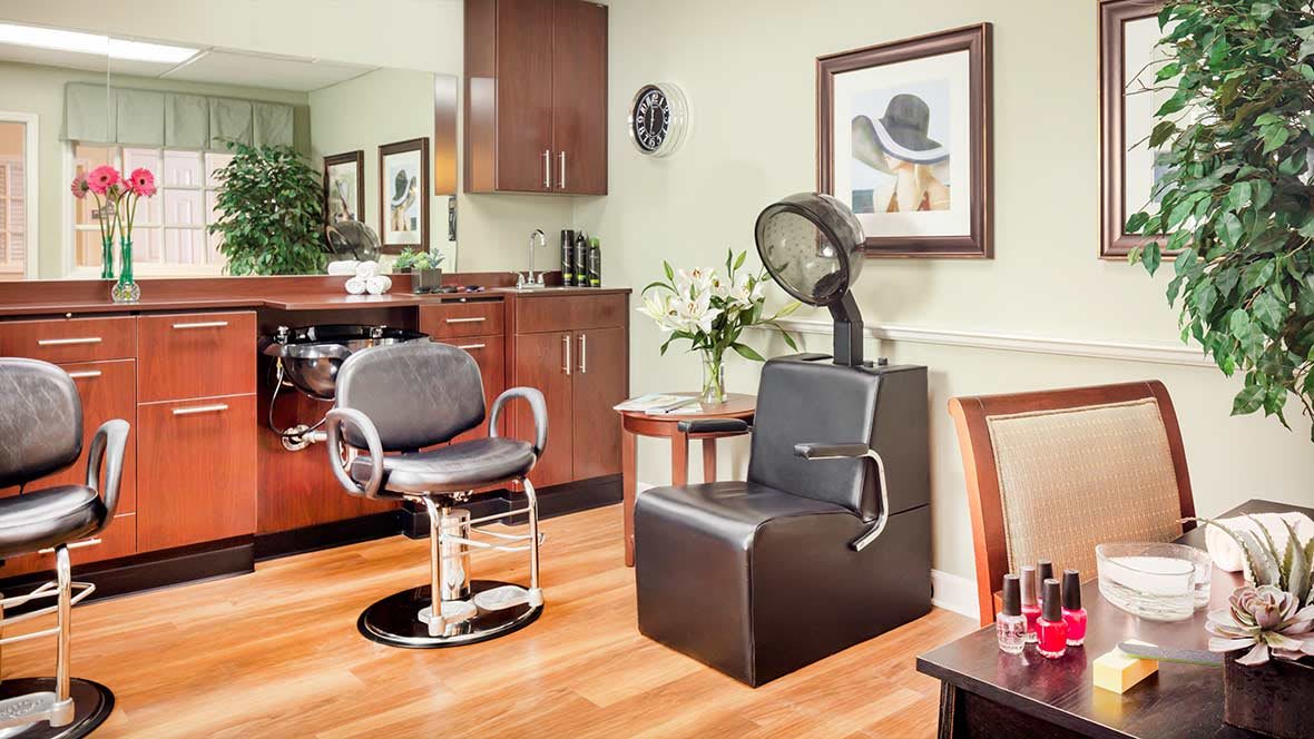 A well-organized hair salon with a styling chair and a hooded hair dryer.