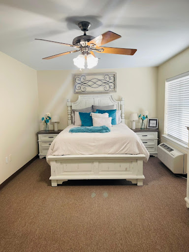 A beautifully arranged bedroom featuring a cozy bed, stylish decor, and ample natural light.