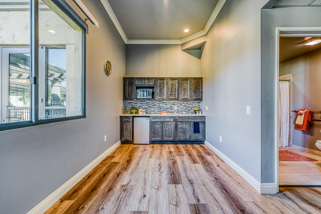 A modern kitchenette with wood flooring and compact layout.