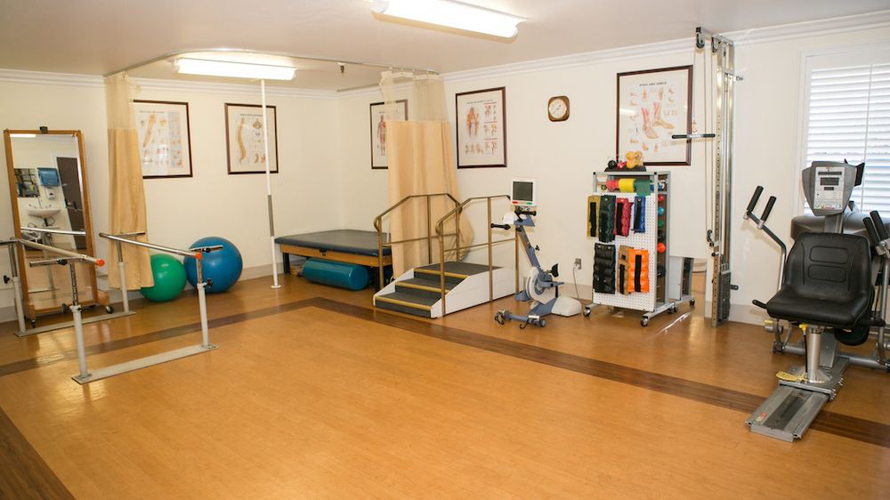 A physical therapy room equipped with exercise equipment and rehabilitation tools.