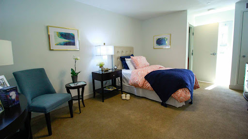 A cozy bedroom featuring a neatly made bed, stylish decor, and tasteful artwork.