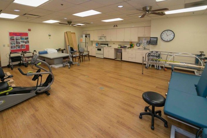 A spacious physical therapy room equipped with exercise and rehabilitation equipment.