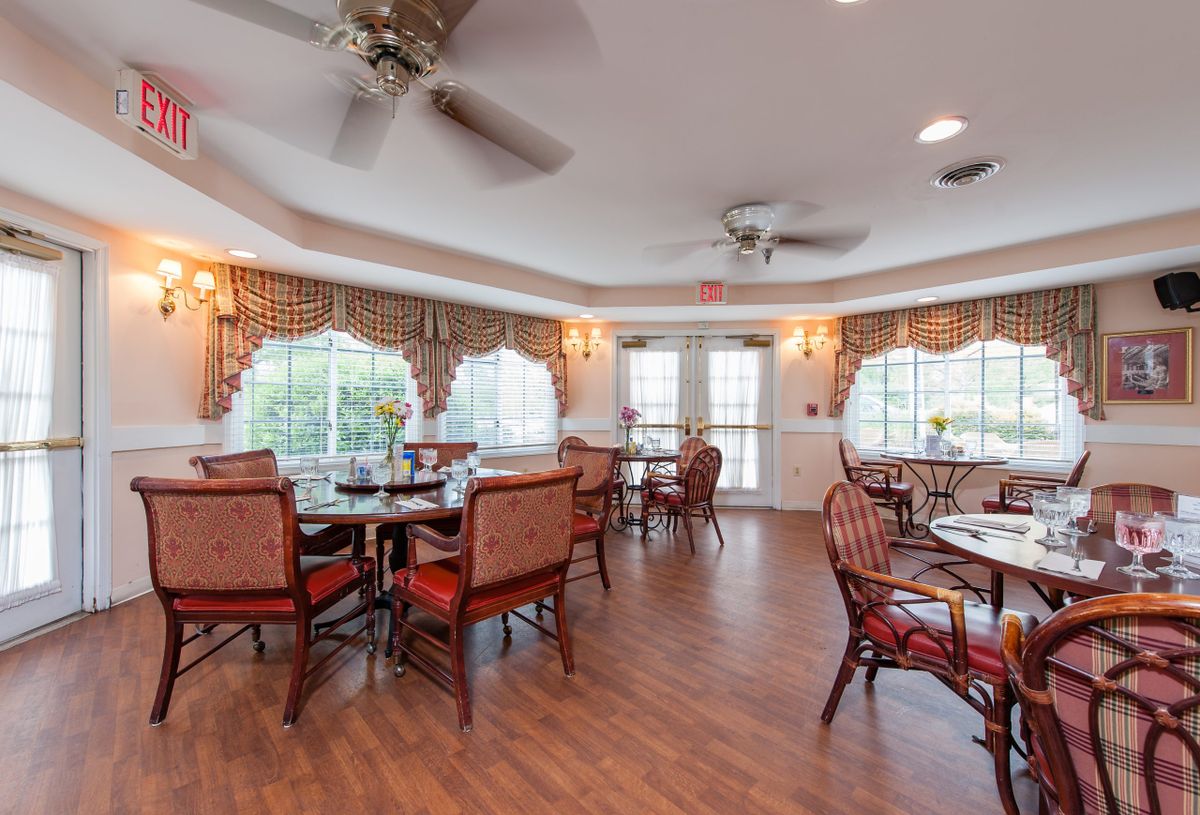 A well-lit dining room with elegant furniture and large windows.
