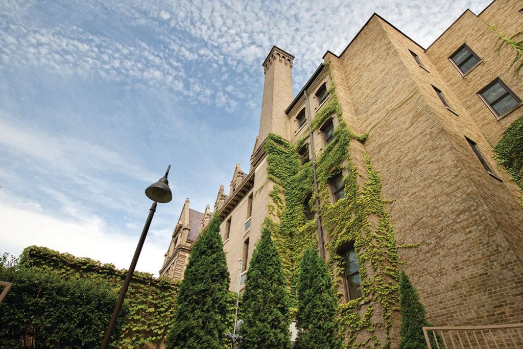 A historic building with ivy-covered walls under a cloudy sky.