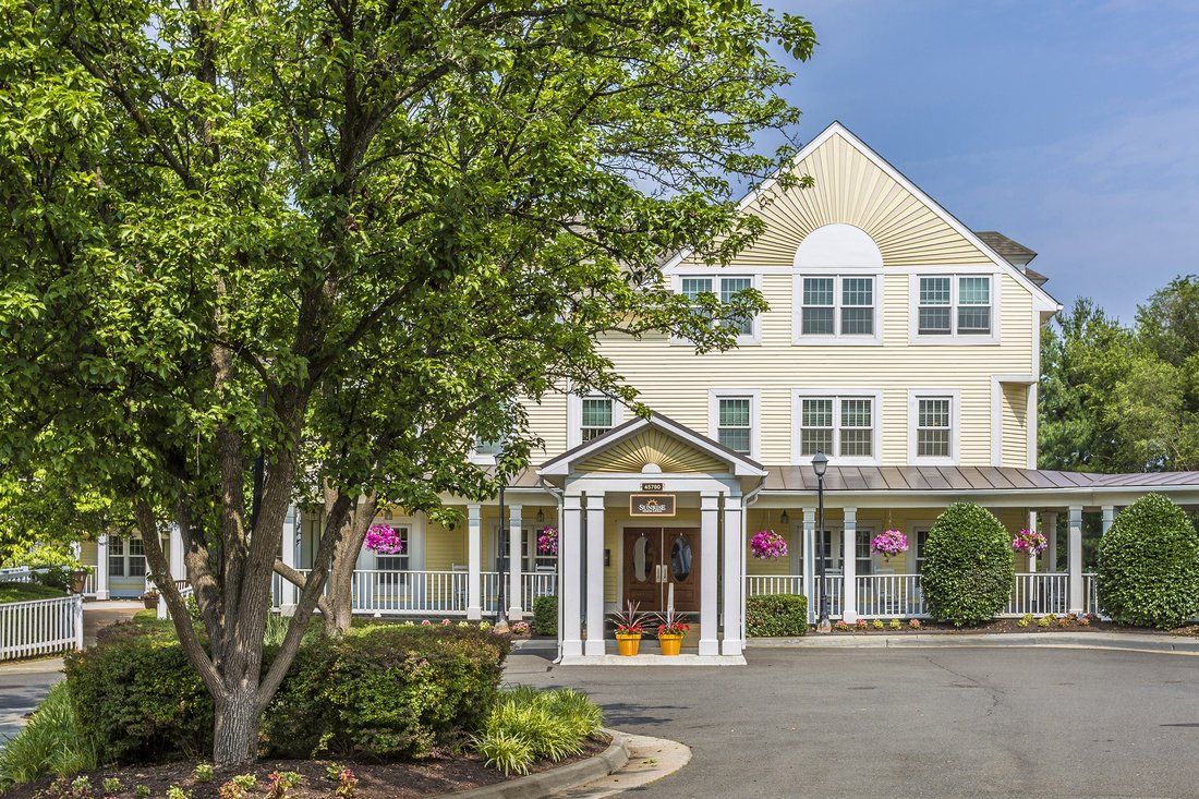 A charming residential building with a tree-lined entrance and well-maintained landscaping.