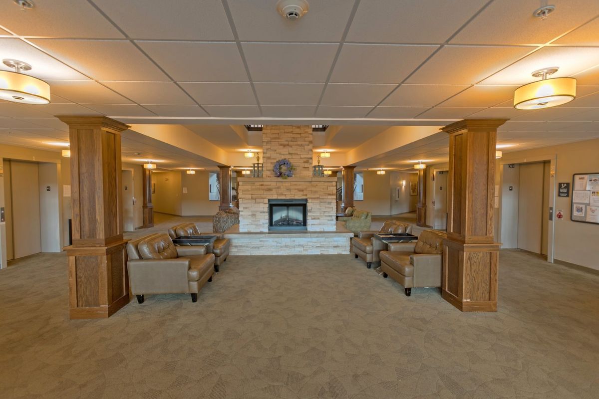 A cozy living room with a central fireplace and comfortable seating arrangements.