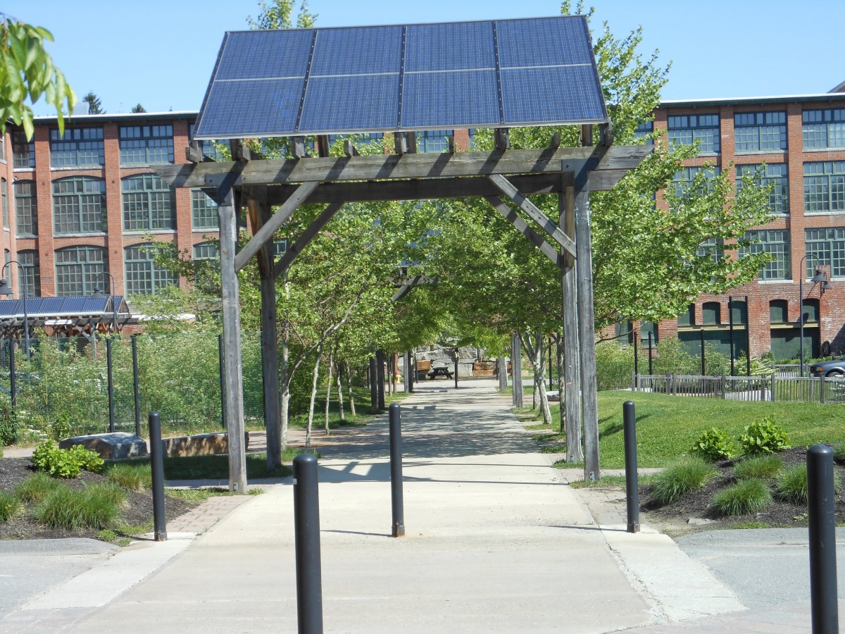 A pedestrian walkway in an urban park featuring solar panels for sustainable energy.