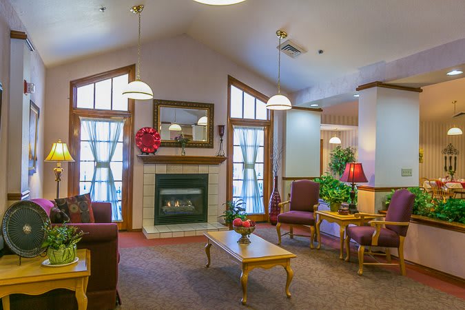 A cozy living room with a fireplace, comfortable seating, and plenty of natural light.