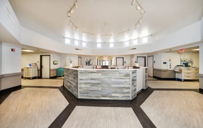 A modern reception area featuring a central desk with bright lighting and contemporary design elements.