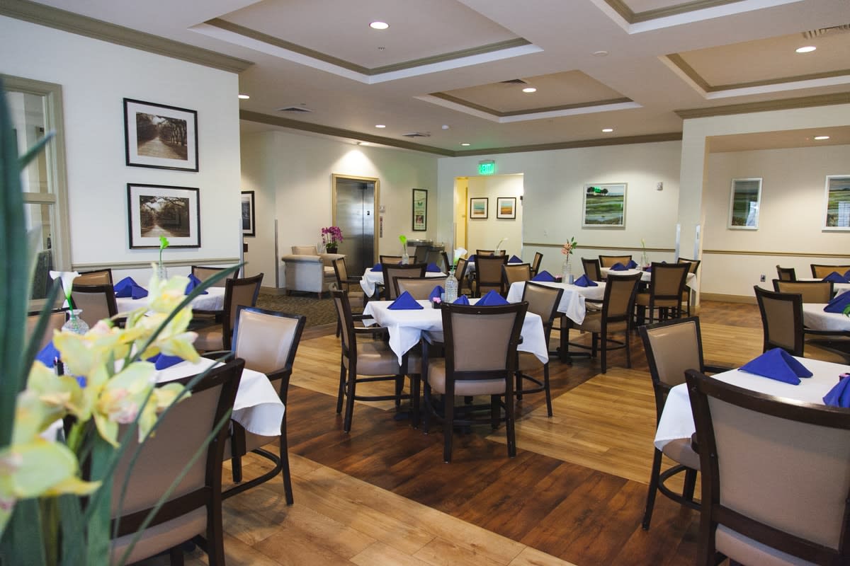 A neatly arranged restaurant dining room with tables set for service.