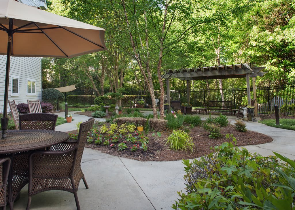 A serene garden patio area with outdoor seating and lush greenery.