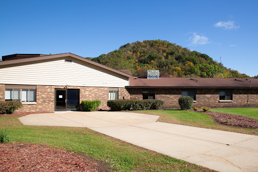 A peaceful facility surrounded by nature under a clear blue sky.