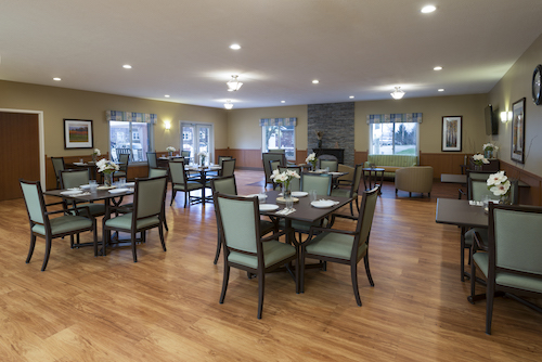A spacious and well-lit dining area featuring modern furniture and a cozy atmosphere.