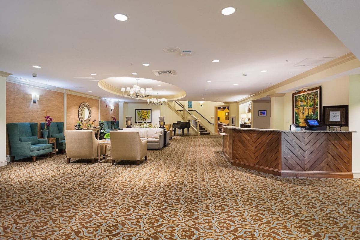 A spacious hotel lobby with a seating area and reception desk.
