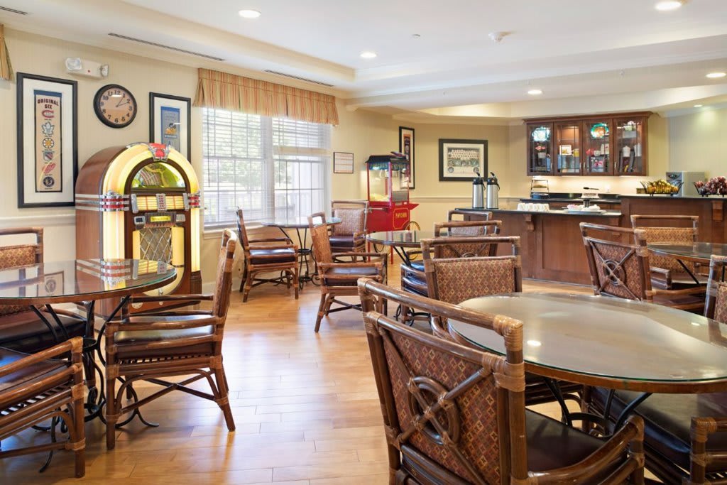 A cozy retro-themed dining area featuring a jukebox and wooden furniture.