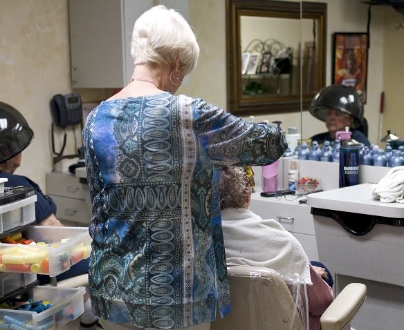A hairdresser working on a client's hair in a salon.